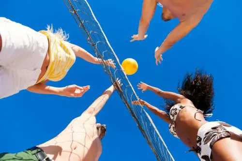 people playing volleyball on the beach